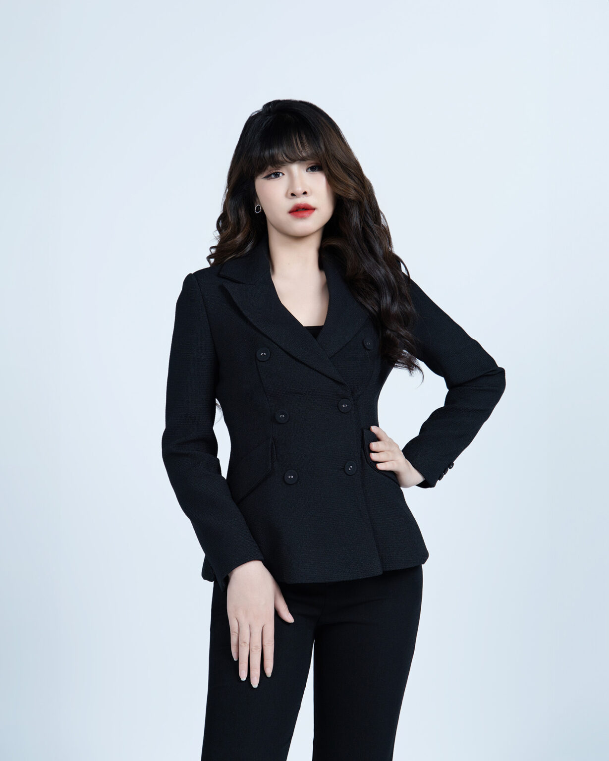 Chụp ảnh profile tại TP.HCM: nữ tóc mái uốn sóng, son đỏ, blazer đen hai hàng khuy, tay chống hông nhìn thẳng ống kính