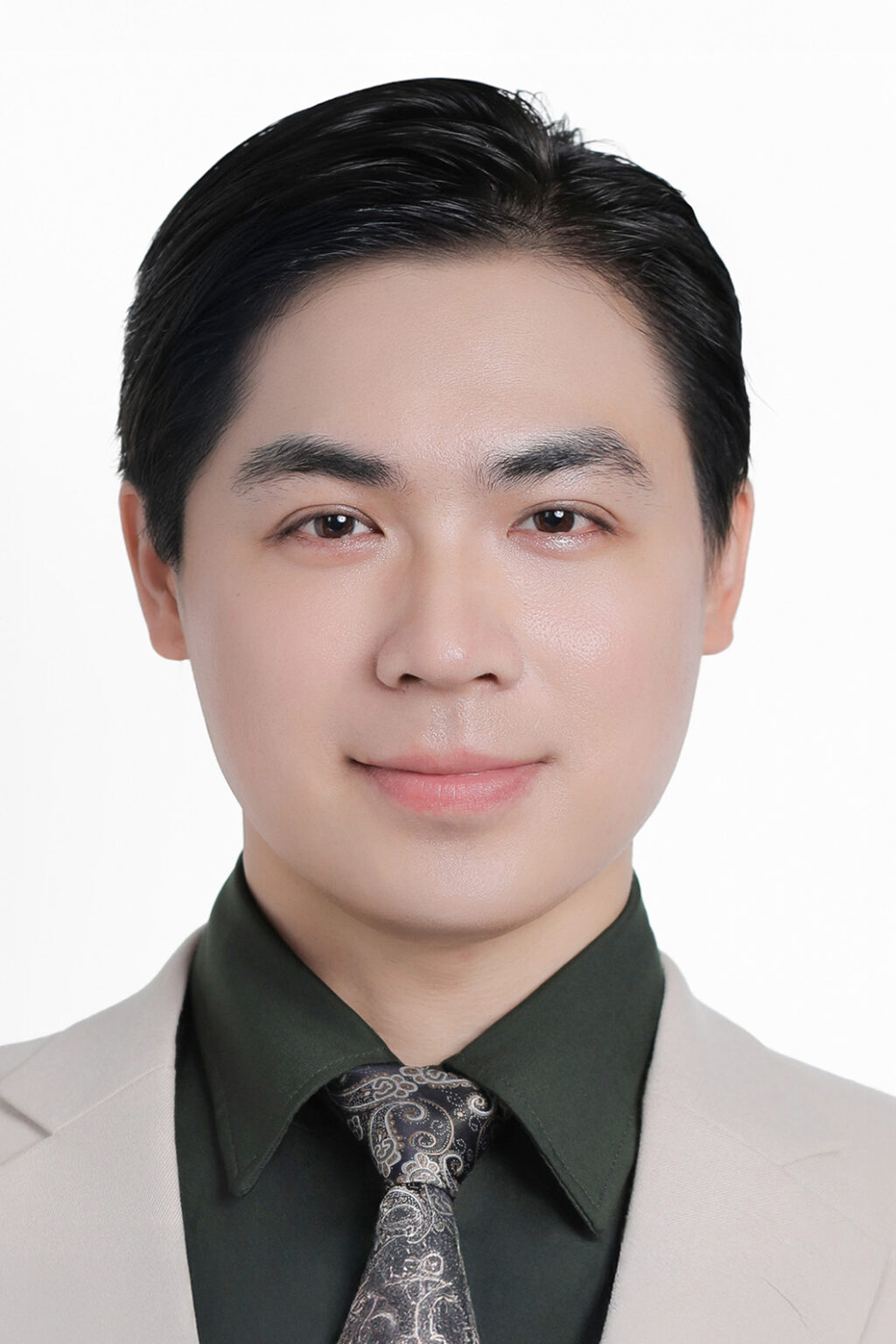 Ảnh thẻ nam nền trắng, vest be, sơ mi xanh rêu, tóc vuốt gọn lộ trán và tai